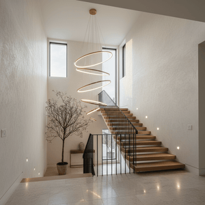 Gold Mega Ribbon LED Pendant Light suspended above a staircase, enhancing the modern interior with its sculptural design.