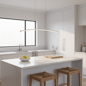 Sleek Maybe Someday Bow LED Pendant light hanging above a modern kitchen island with a bowl of lemons.