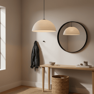 Antique white rattan pendant light hanging above a wooden table with decor and a mirror in a cozy entryway.