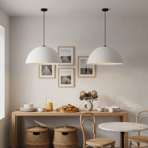 Detail of a dining area featuring a small rattan pendant light above a wooden table with plates and pastries.