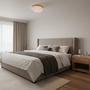 Polished gold flush‑mount ceiling light with textured glass shade, glowing in a bedroom