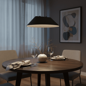 Black felt pendant light hanging over a round wooden dining table