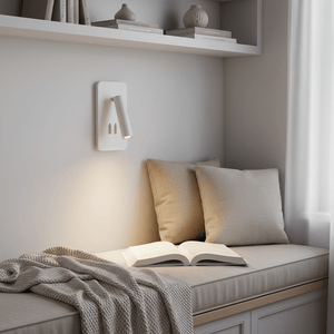 A white wall-mounted bedside reading light above a cozy seating area with cushions and an open book.
