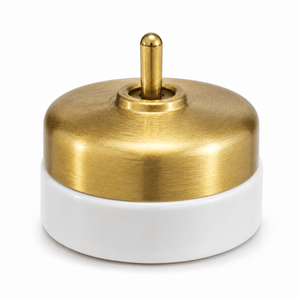 Heritage brass and porcelain switch with a brushed brass top and white porcelain base.