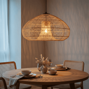 Chantelle Rattan Pendant light hanging above a round dining table set with dishes and glassware, casting soft shadows.