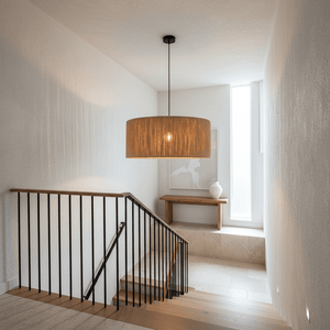 Clocolan Raffia Large Pendant Light hanging in a modern stairwell, casting warm light and shadows.