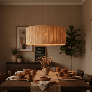 Large raffia pendant light hanging above a rustic dining table set with earthy dishware.