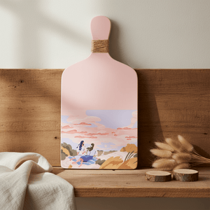 Light pink decorative wooden board featuring a scenic illustration, displayed on a wooden shelf with natural elements.