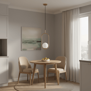 Luna Short G9 Pendant Light in gold hanging over a small wooden dining table with two chairs and a bowl of fruit.