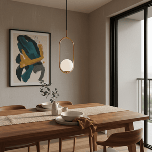 Luna Short G9 Pendant Light in gold hangs above a wooden dining table, complemented by decorative elements.