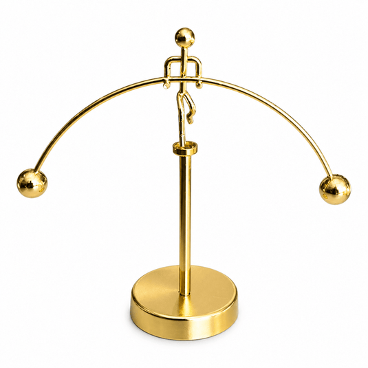 Stylized gold figurine of a balancing man with a polished finish, showcasing movement and modern design.