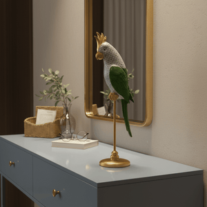 A decorative parrot figurine in green, gold, and white stands on a gold base atop a light blue console table.