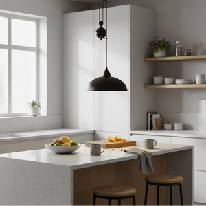 Colchester Black Pulley Pendant Light hanging over a kitchen island with fruits and mugs on the counter.