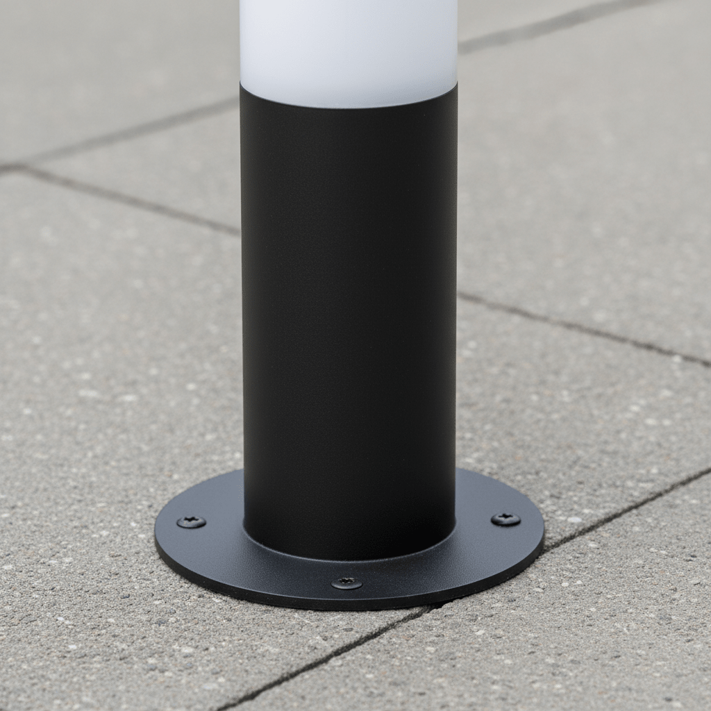 Close-up of the base of a black LED bollard light installed on a concrete surface, showcasing its sturdy mounting.