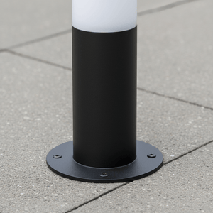 Close-up of the base of a black LED bollard light installed on a concrete surface, showcasing its sturdy mounting.