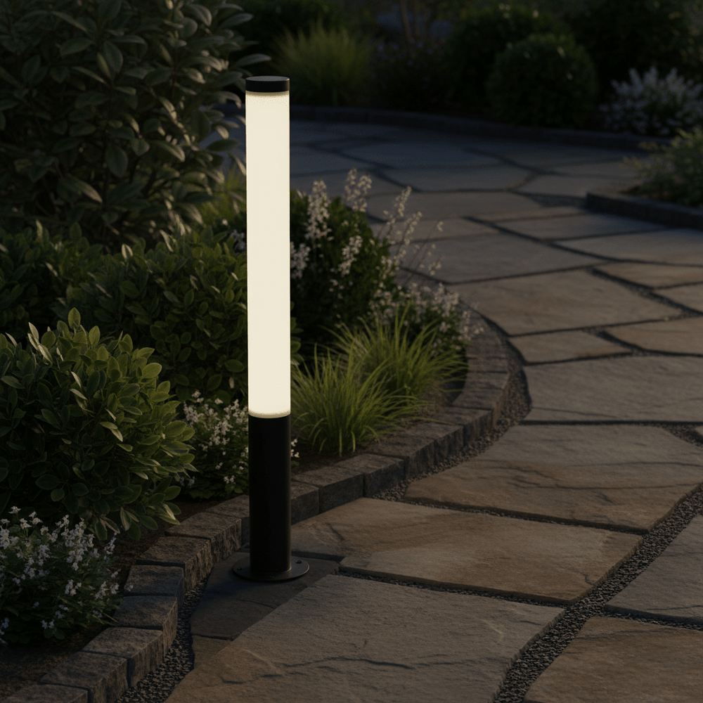 20W black LED bollard light illuminating a stone pathway surrounded by greenery and flowers.