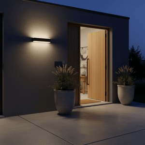 Rectangular wall light casting warm glow on dark wall beside open door marked 16, with two potted plants on concrete patio.