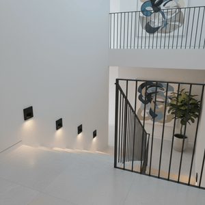 Recessed black LED step lights illuminating a modern staircase with a railing and artwork.