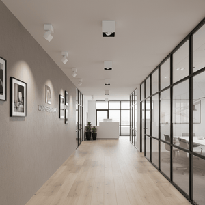 Modern office hallway featuring multiple white surface mount downlights illuminating a textured wall and framed artwork.