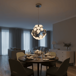 A chrome pendant light with a spherical design hangs above a round wooden dining table set with plates and glasses.
