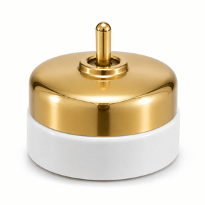 Heritage brass and porcelain switch with polished brass top and white porcelain base.