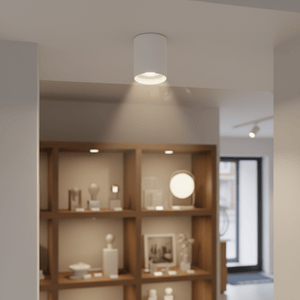White adjustable surface-mounted downlight illuminating a display shelf in a modern interior.