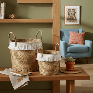 Woven storage baskets with white fringe on a wooden shelf, alongside a notebook and glasses.