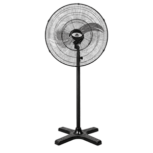 Black industrial floor fan with circular steel grill, tall pole, and cross-shaped base against a green background