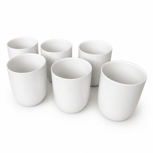 Set of six plain white ceramic tea cups arranged closely together, showcasing their smooth finish and simple design.