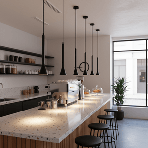 A modern kitchen bar featuring multiple black pendant lights above a speckled countertop with a coffee machine.