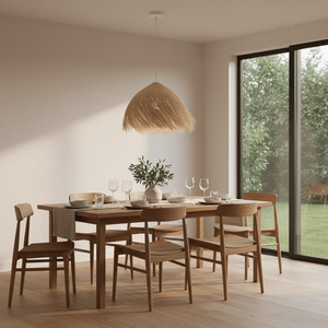 Feather Rattan Pendant Light hanging above a wooden dining table set with dishes and glasses, creating a warm ambiance.
