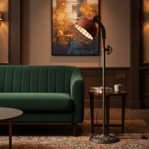 Rustic Urban Forge Floor Lamp beside a green sofa, featuring a red shade and industrial wire detail.