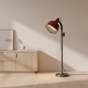 Rustic Urban Forge Floor Lamp with a red shade and industrial wire detail beside a wooden cabinet.