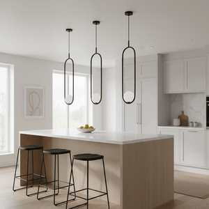 Three black pendant lights hang above a modern kitchen island with wooden stools and a bowl of lemons.