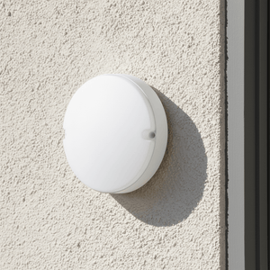 Close-up of a 15W LED SMD round bulkhead light mounted on a textured wall, showcasing its sleek white design.