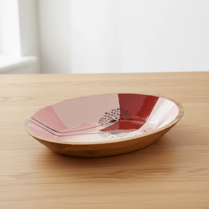 wooden dandelion-pattern bowl on a table beside a cup and folded napkin
