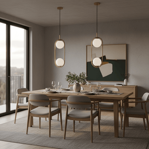 Luna Double G9 Pendant Light in gold above a modern dining table set for dinner.