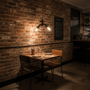 Industrial-style LED pendant light illuminating a cozy dining table in a rustic setting with exposed brick walls.