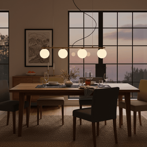 Linear 4 Light Pendant in gold above a dining table, illuminating a cozy dining setup with chairs and decor.