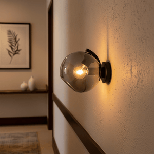 Close-up of the Bubble Glass Wall Light mounted on a wall, showcasing its rounded glass shade and warm illumination.