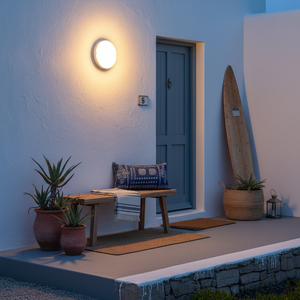 Outdoor wall light illuminating a porch with a bench and potted plants at dusk.