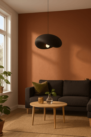 Obsidian Drift 500 Pendant Light hanging above a cozy living room setup with a dark sofa and wooden coffee table.