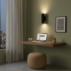 Black wall light illuminating a modern workspace with a floating desk and laptop.