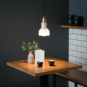 Stylish Retro Y White Marble & Gold Pendant light above a wooden table with coffee cups and a vase.