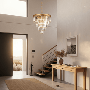 Satin gold 5-tier crystal chandelier hanging in a modern foyer with a wooden console table.