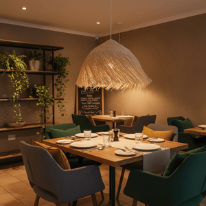 Feather Rattan Pendant Light hanging above a dining table set with plates and glasses in a cozy restaurant.