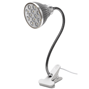 A silver and white desk clip-on LED grow light with a flexible neck and a round head featuring multiple LED bulbs.
