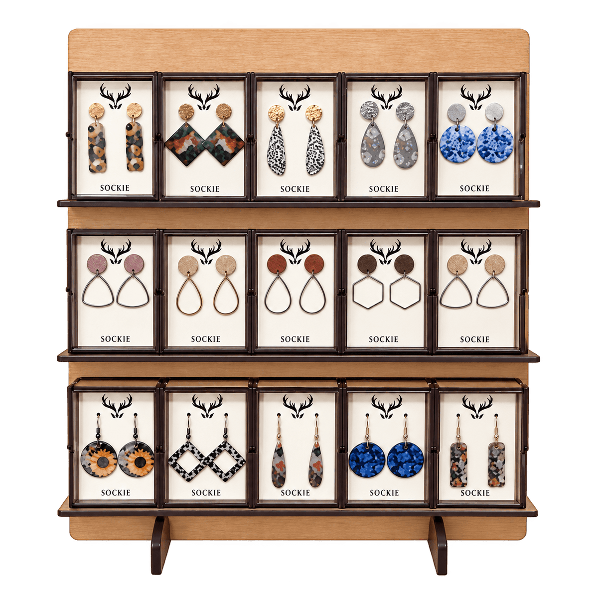 Wooden display stand with compartments, each showing SOCKIE earrings and deer antler logo on white cards.