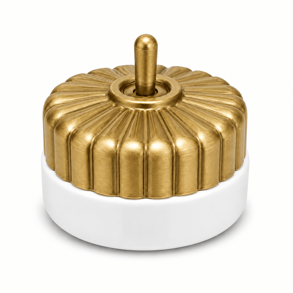 Brass switch with a fluted design atop a white porcelain base, featuring a central toggle.