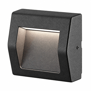 Black surface-mounted LED foot light with a rectangular design and a textured finish, featuring a warm light source.